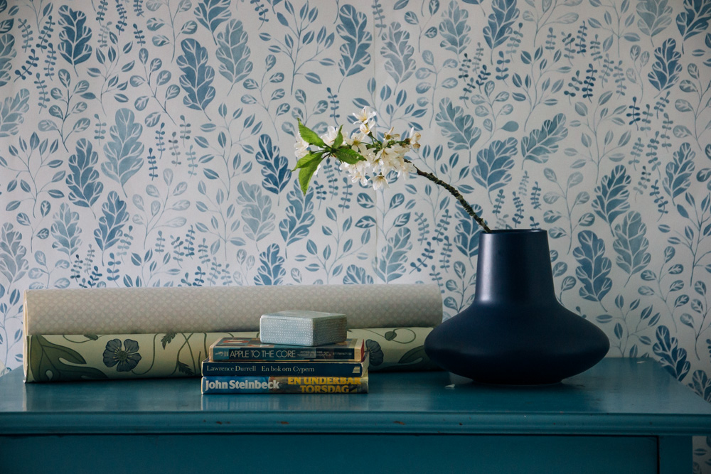 bl&aring; tapet med blad och bl&aring; byr&aring;