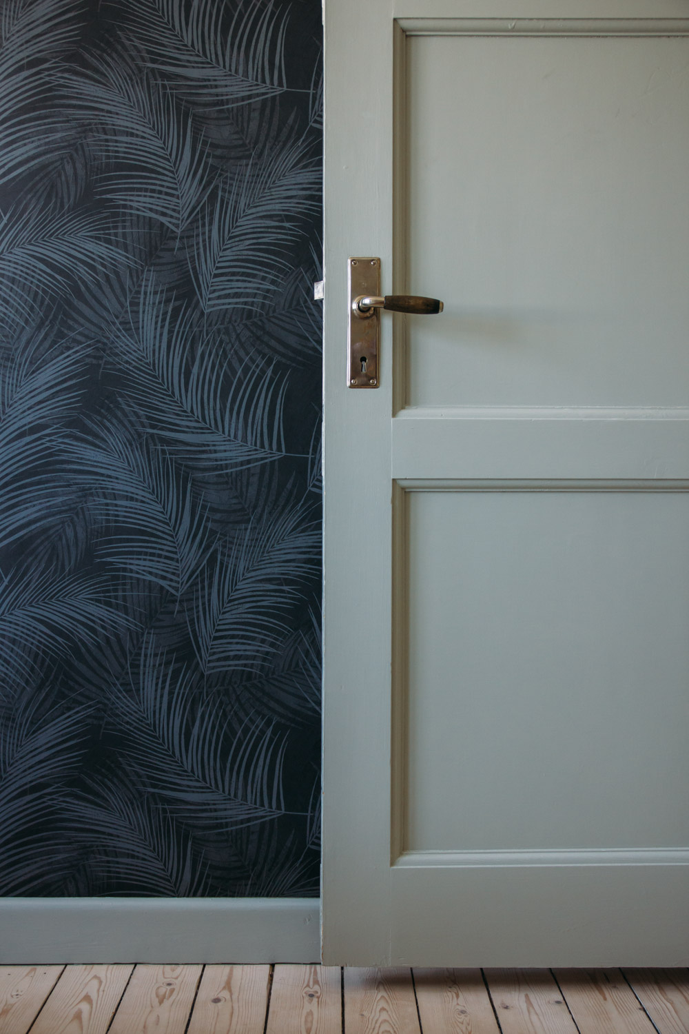 gr&aring; tapet med stora blad palma