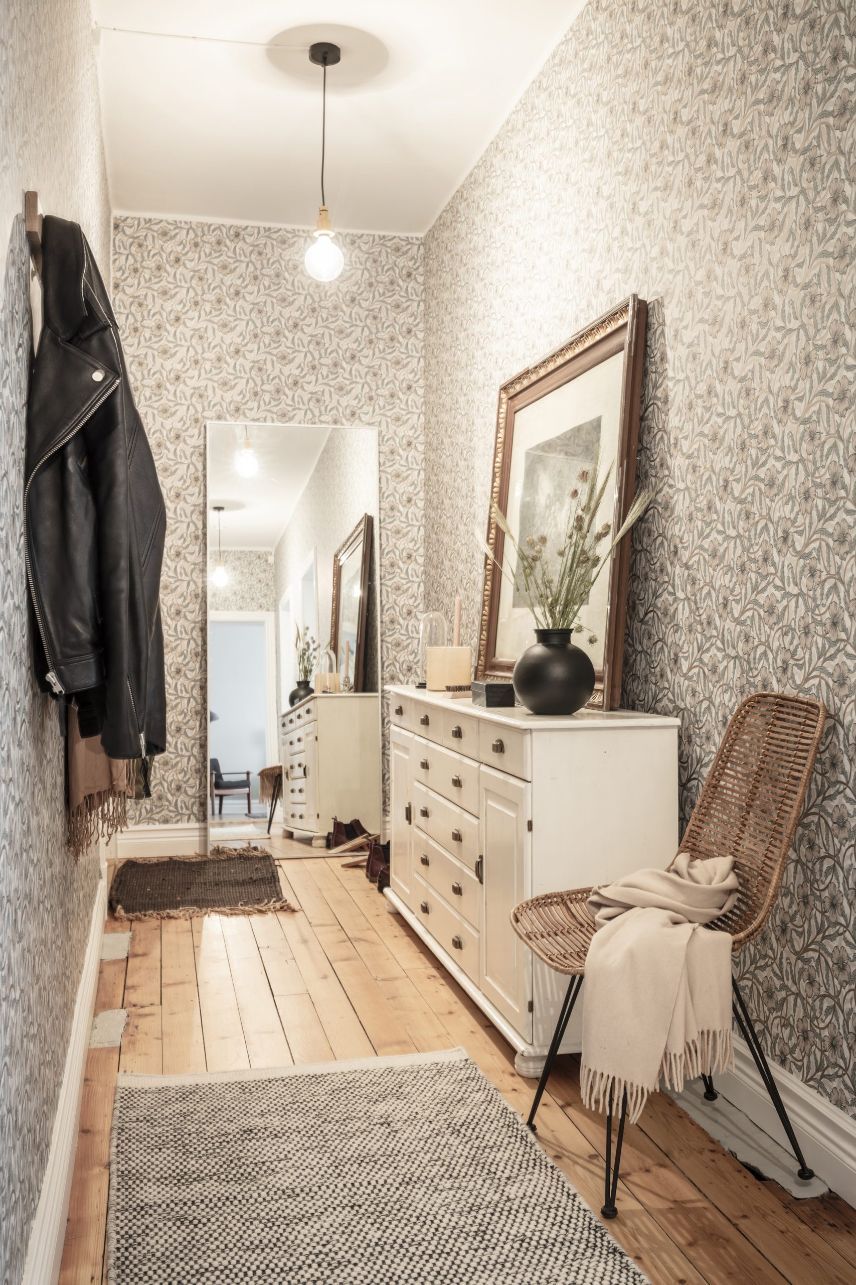 gr&aring; blommig tapet i hall med spegel